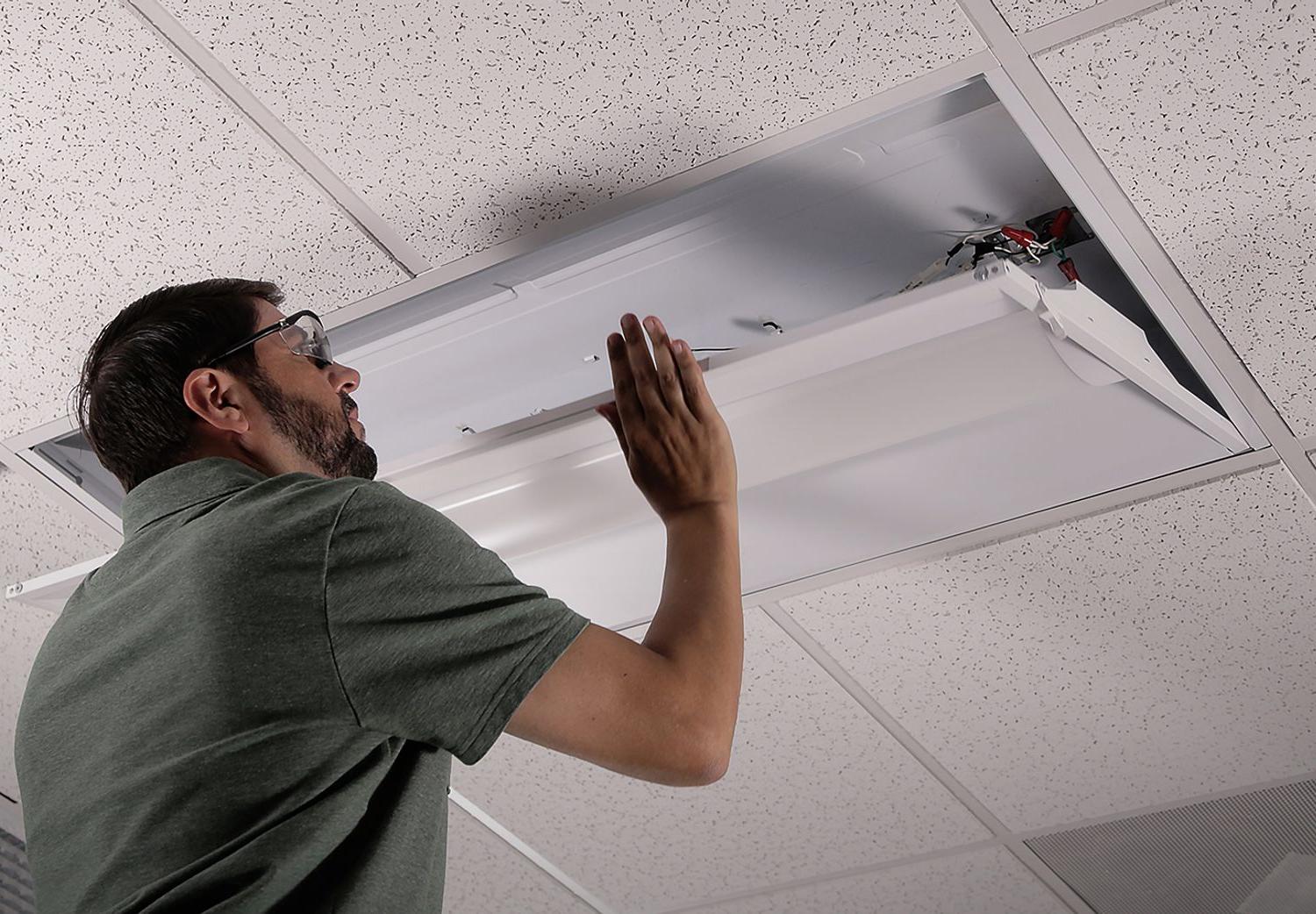 contractor installing zrrk retrofit troffer in drop ceiling
